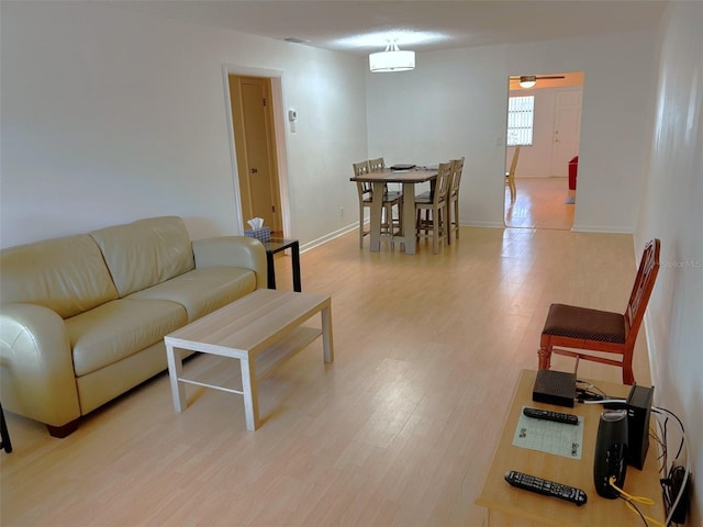 living room featuring light wood-style flooring and baseboards