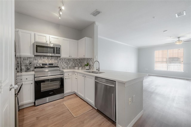 kitchen featuring stainless steel appliances, white cabinetry, and sink