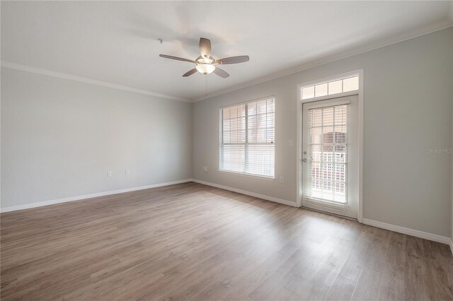 spare room featuring hardwood / wood-style floors, ceiling fan, and crown molding