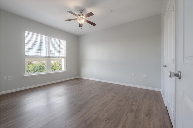 empty room with ceiling fan and dark hardwood / wood-style flooring