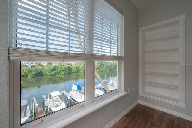 room details featuring built in shelves, a water view, and wood-type flooring