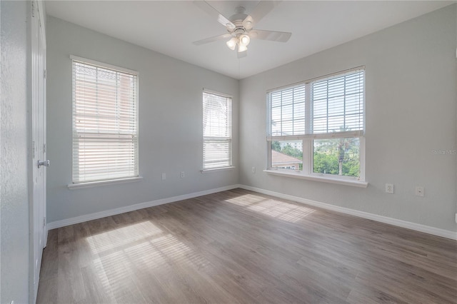 spare room with hardwood / wood-style flooring, ceiling fan, and a healthy amount of sunlight