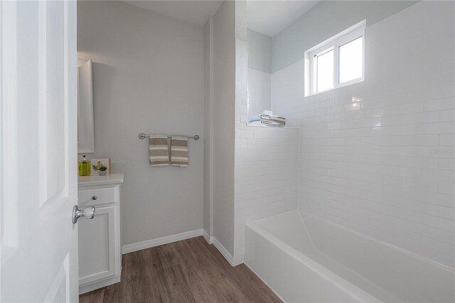 bathroom with hardwood / wood-style flooring and tub / shower combination