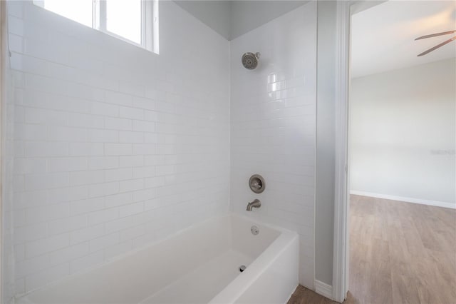 bathroom with wood-type flooring and tiled shower / bath