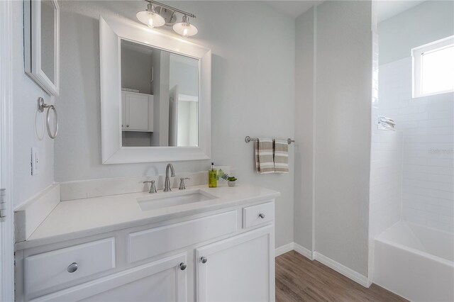 bathroom with vanity, wood-type flooring, and tiled shower / bath