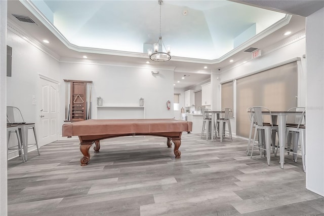 game room with light wood-type flooring, a towering ceiling, ornamental molding, and billiards