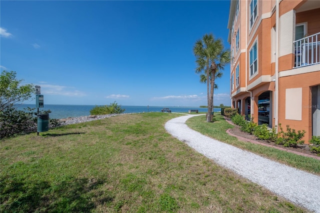 view of property's community with a yard and a water view