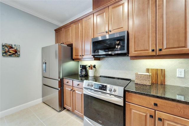 kitchen with appliances with stainless steel finishes, dark stone counters, backsplash, ornamental molding, and light tile patterned flooring