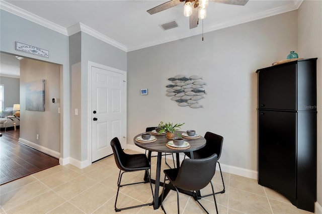 tiled dining room featuring ceiling fan and crown molding