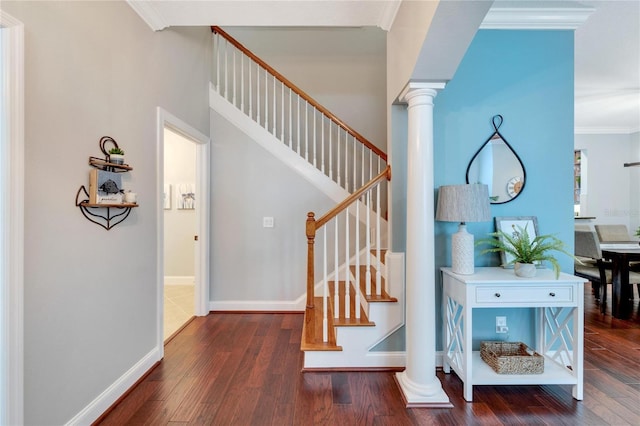 staircase with decorative columns, hardwood / wood-style flooring, and ornamental molding