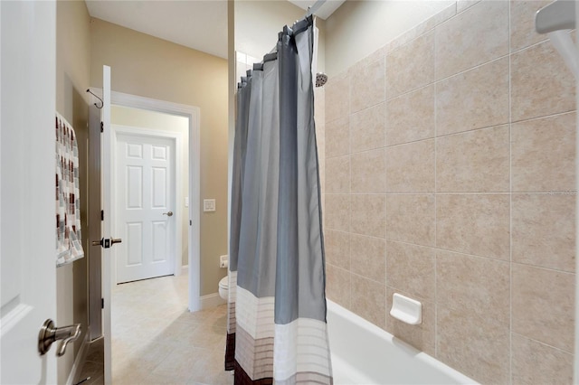 bathroom featuring toilet and shower / bath combination with curtain