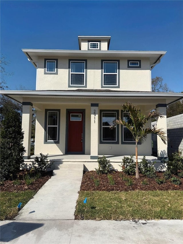 traditional style home featuring stucco siding and a porch