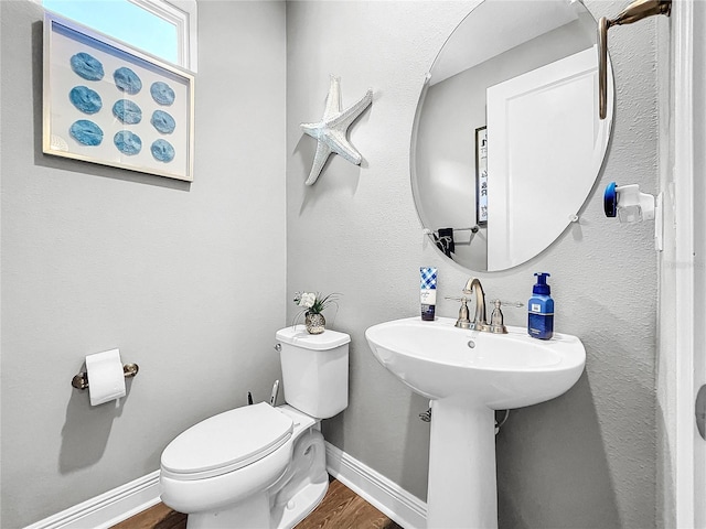 bathroom featuring hardwood / wood-style flooring and toilet