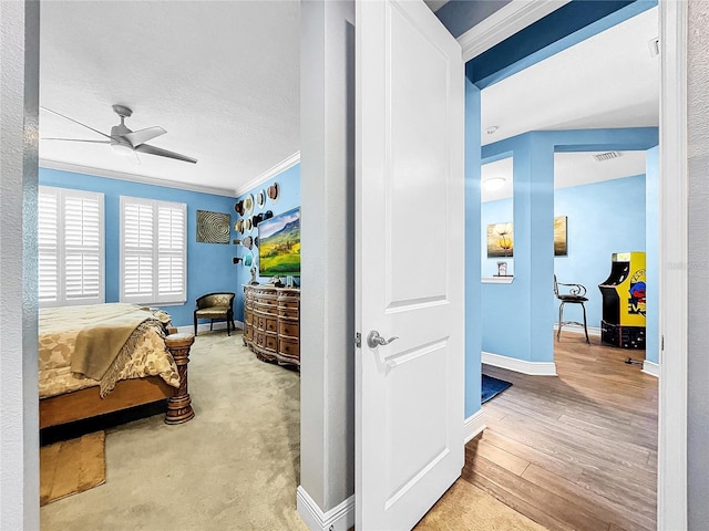 bedroom with hardwood / wood-style flooring, ceiling fan, and crown molding