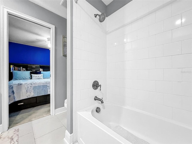 bathroom featuring tile patterned flooring, toilet, a textured ceiling, and tiled shower / bath