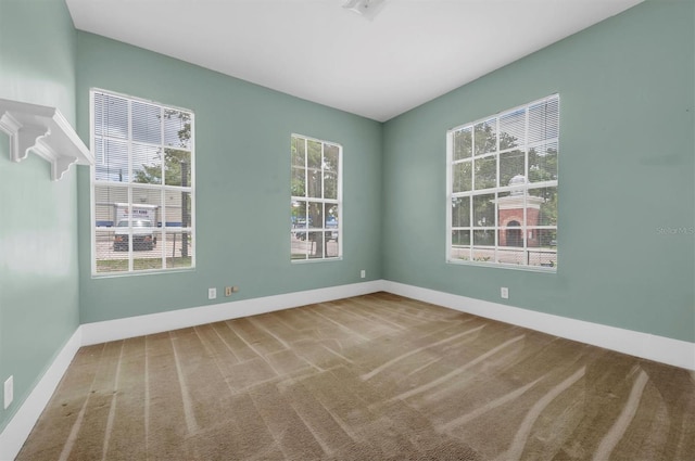 empty room featuring baseboards and carpet flooring