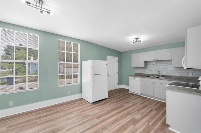 kitchen with decorative backsplash, sink, white appliances, and light wood-type flooring