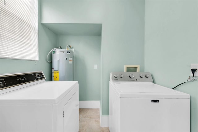 clothes washing area with laundry area, water heater, independent washer and dryer, and light tile patterned floors