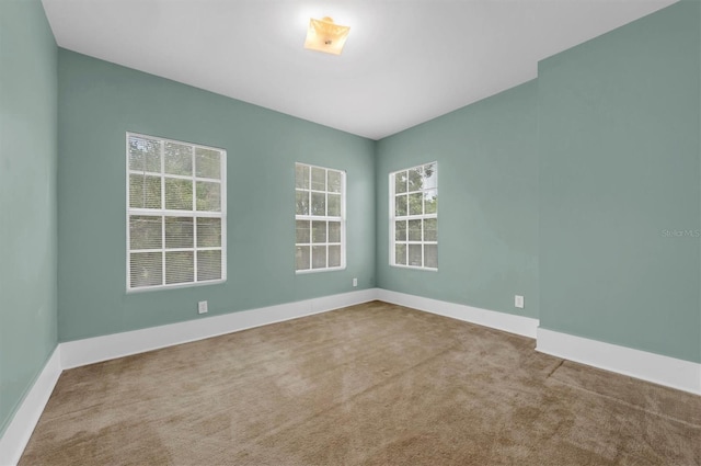 carpeted spare room with baseboards