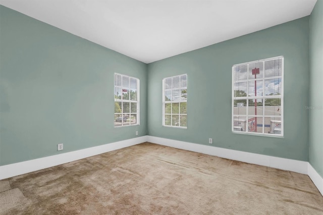 spare room featuring carpet and baseboards