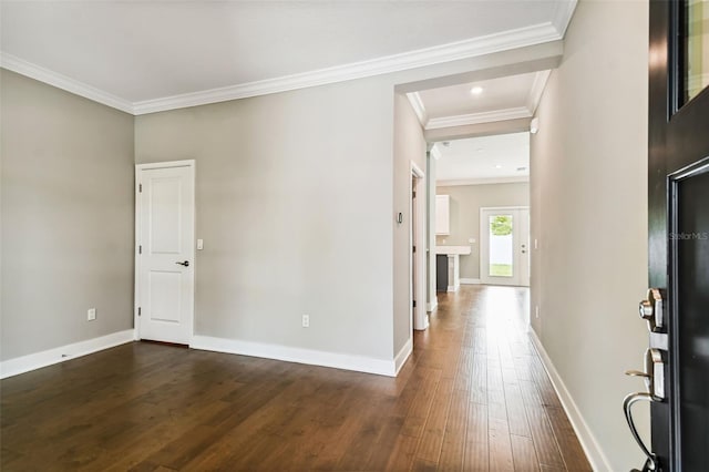 interior space with dark wood-style floors, crown molding, and baseboards