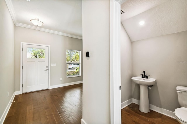 bathroom with wood-type flooring, vaulted ceiling, toilet, and ornamental molding