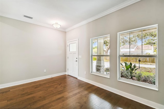 entrance foyer featuring dark hardwood / wood-style floors, crown molding, and a healthy amount of sunlight