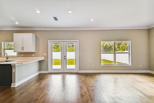 kitchen featuring light countertops, dark wood-type flooring, a wealth of natural light, and baseboards