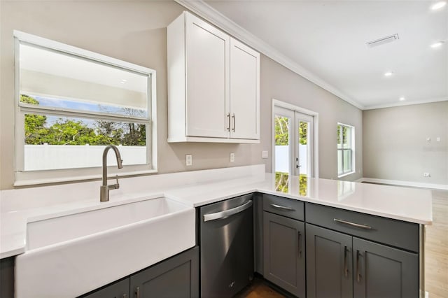 kitchen featuring kitchen peninsula, white cabinetry, sink, and stainless steel dishwasher