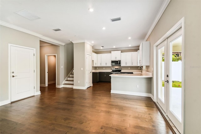 kitchen with appliances with stainless steel finishes, dark wood-type flooring, and visible vents