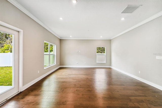 unfurnished room featuring baseboards, dark wood finished floors, visible vents, and crown molding