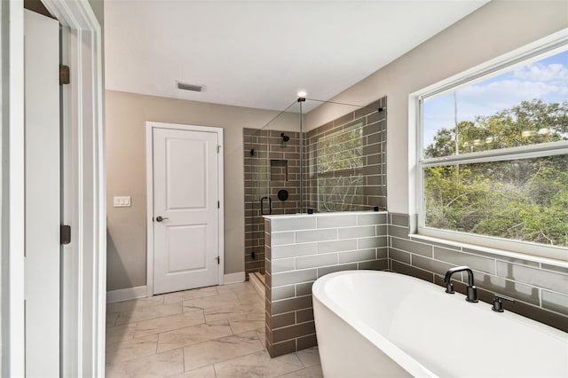 bathroom with visible vents, baseboards, marble finish floor, a freestanding tub, and a shower stall