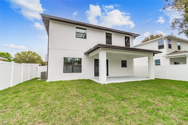 rear view of property with a patio, a yard, a fenced backyard, and stucco siding