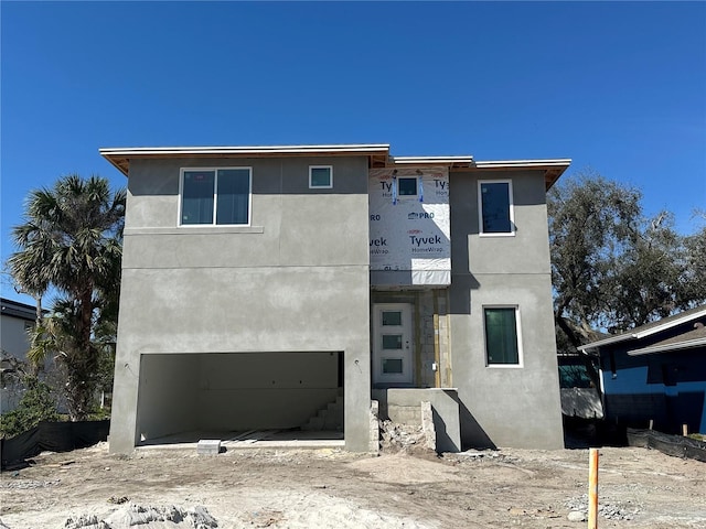 view of front of property featuring an attached garage and stucco siding