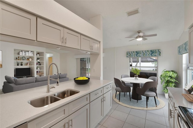 kitchen with ceiling fan, light tile patterned floors, sink, gray cabinets, and stainless steel electric range oven