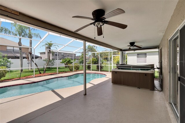 view of pool featuring a patio, a hot tub, glass enclosure, ceiling fan, and a yard