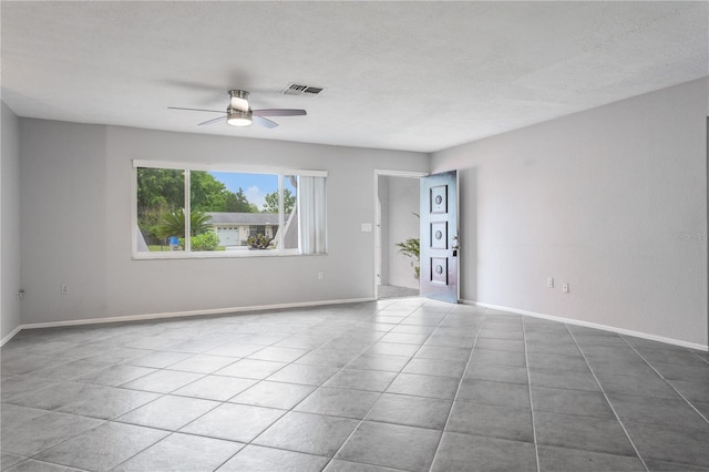 unfurnished room featuring ceiling fan, light tile patterned flooring, and a textured ceiling