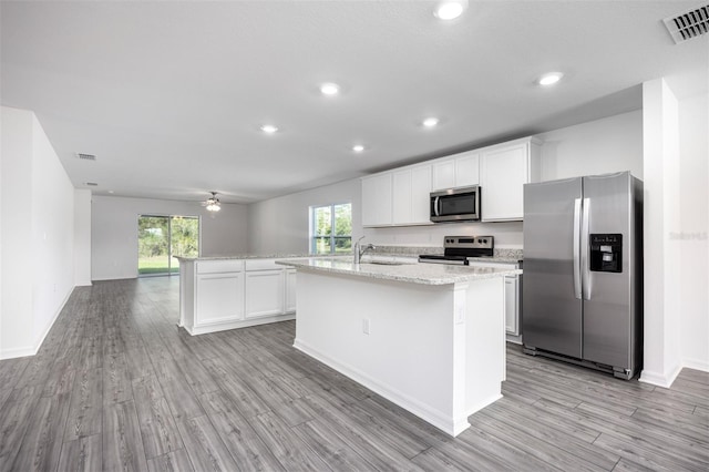 kitchen with white cabinetry, a kitchen island with sink, and stainless steel appliances