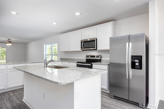 kitchen with ceiling fan, sink, a kitchen island with sink, white cabinets, and appliances with stainless steel finishes