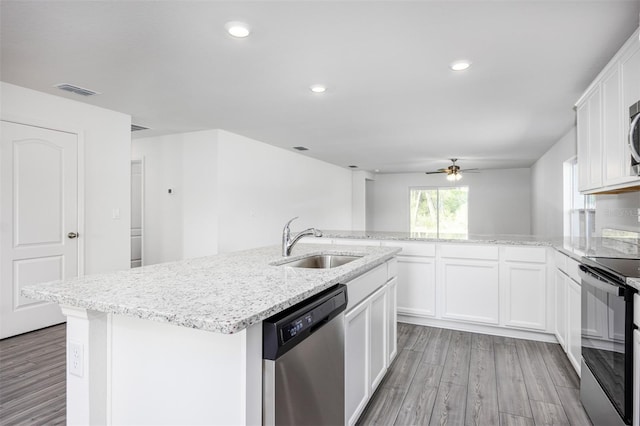 kitchen with an island with sink, stainless steel appliances, white cabinetry, and sink