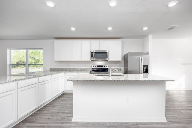 kitchen featuring white cabinetry, an island with sink, and appliances with stainless steel finishes