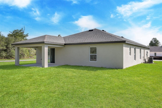 rear view of house with a lawn, a patio area, and central AC unit