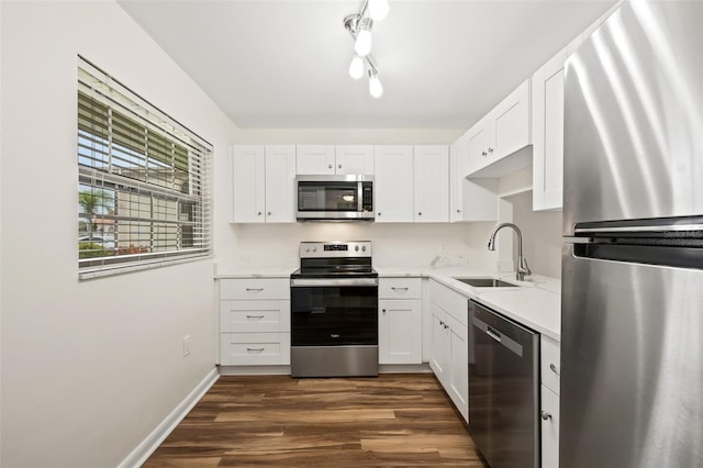 kitchen featuring white cabinets, stainless steel appliances, dark wood-type flooring, and sink