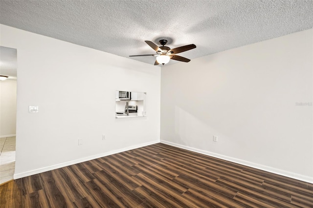 unfurnished room featuring a textured ceiling, dark hardwood / wood-style flooring, and ceiling fan