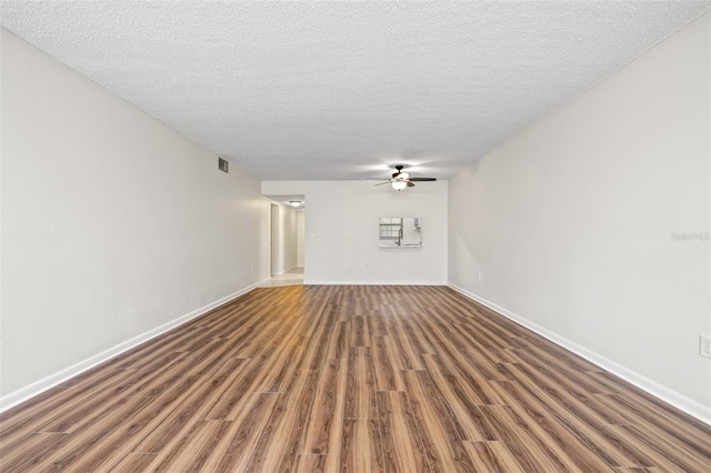 unfurnished living room featuring ceiling fan, dark hardwood / wood-style flooring, and a textured ceiling