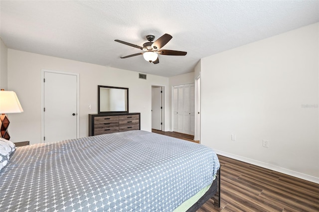 bedroom featuring a textured ceiling, ceiling fan, and dark wood-type flooring