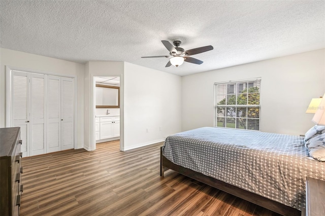 bedroom with ensuite bathroom, ceiling fan, a textured ceiling, dark hardwood / wood-style flooring, and a closet