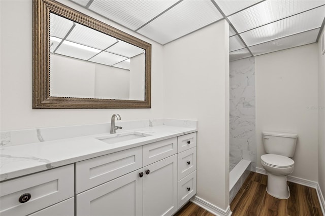 bathroom with vanity, toilet, wood-type flooring, and a shower