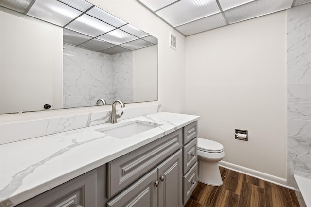 bathroom featuring toilet, vanity, and hardwood / wood-style flooring