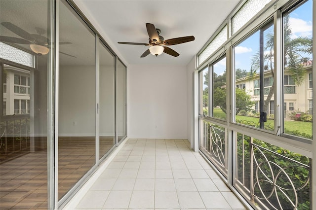 unfurnished sunroom with ceiling fan